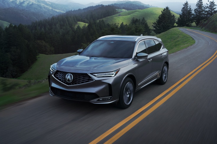 Liquid Carbon Metallic車色2026 Acura MDX搭載先進組合行駛於道路的四分之三視角畫面（豪華高性能SUV）。