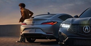 兩輛2023 Integra在屋頂停車場上,其中一輛展示後方視角,另一輛展示前方視角 兩輛2023 Integra在屋頂停車場上,其中一輛展示後方視角,另一輛展示前方視角