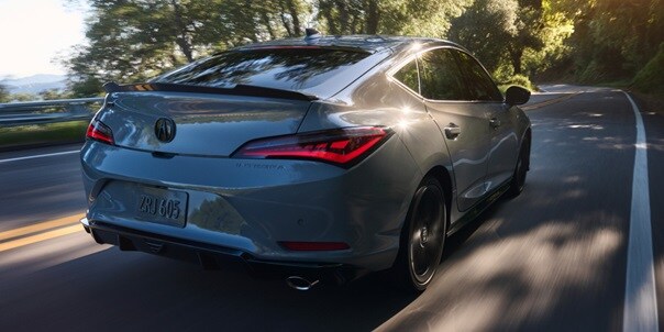 Urban Gray Pearl色2026 Acura Integra汽車在路上行駛。 Urban Gray Pearl色2026 Acura Integra汽車在路上行駛。