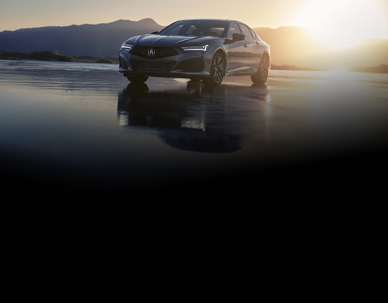 2026 Acura TLX with Technology Package in Liquid Carbon Metallic, front three-quarter view at sunset with mountains (Premium Sport Sedan). 2026 Acura TLX with Technology Package in Liquid Carbon Metallic, front three-quarter view at sunset with mountains (Premium Sport Sedan).
