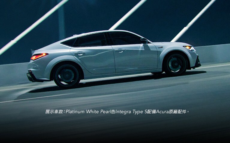 Platinum White Pearl色Acura Integra Type S穿越橋樑的側面視角。