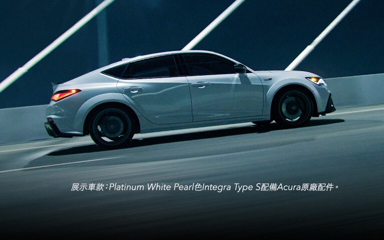 Platinum White Pearl色Acura Integra Type S穿越橋樑的側面視角。
